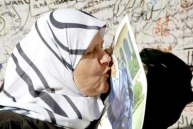 لبنانية مسلمة تقبل صورة الشهيد الحريري قرب قبره في ساحة الشهداء ببيروت أمس