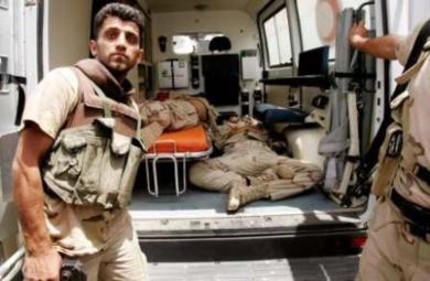 حارس وطني عراقي يفتح سيارة الاسعاف التي تحمل ثلاثه من زملاءه الموتى 