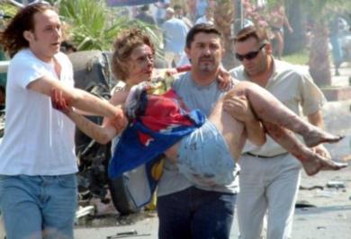 مواطنون يحملون امراة مصابة في بسبب الانفجار