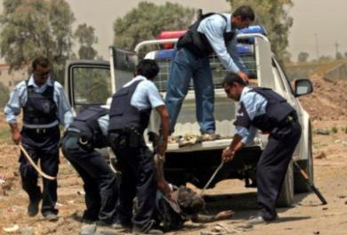 عناصر من الشرطة العراقية يحملون جثة الانتحاري 