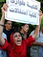 امرأة مصرية تحمل لافتة كتب عليها "كفاية طوارى وكفاية اعتقالات"