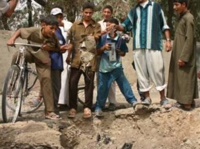 مجموعة من الصبية يلهون حول حفرة كبيرة في الارض