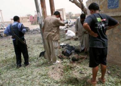 عراقيون ينظرون الى جسم احد القتل الهجوم