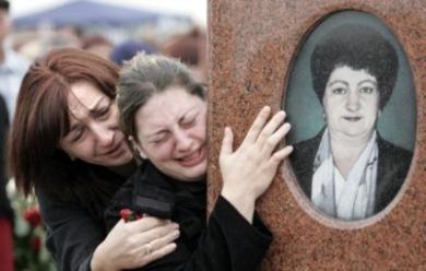 امرأة روسية تبكي امام قبر والدتها