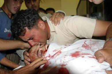 فلسطيني يقبل جثة القتيل نهاد ابو غانم