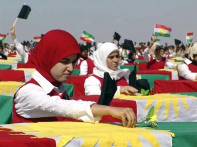 نساء اكراد يضعن الورد على رفات القتلى