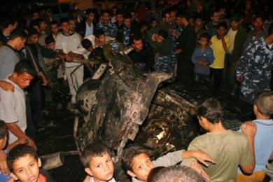 فلسطينيون يشاهدون حطام احدى السيارات المتضررة