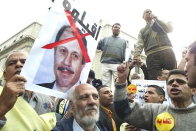 ناشط من حركة كفاية يحمل صورة وزير الداخلية وكتب عليها "اقيلوه"