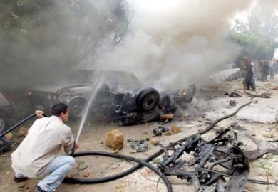 مواطن لبناني يشارك في عملية إطفاء النيران المشتعلة في السيارات في موقع الانفجار أمس