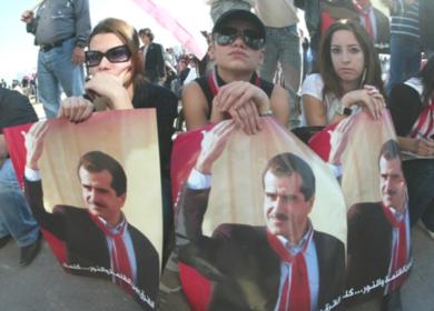 لبنانيات يحملن صوراً لراحل جبران تويني خلال تشييع جنازتة امس