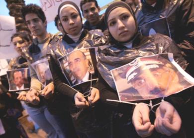 فتيات لبنانيات يحملن صور قادة لبنانيون القي القبض عليهم لتحقيق في اغتيال رفيق الحريري