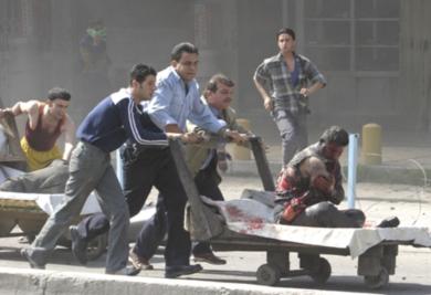 عراقيون ينقلون احد الجرحى بترت يداه في انفجار سيارة مفخخة في منطقة الكرادة
