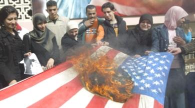متظاهرون يحرقون العلم الامريكي احتجاجاً على التدخلات الامريكية في البلاد