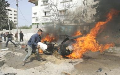 فلسطيني يقوم بإخماد حريق في احدى السيارات التي استهدفت
