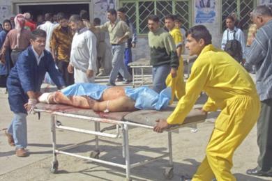 عراقيان يحملان جثة احد القتلى 