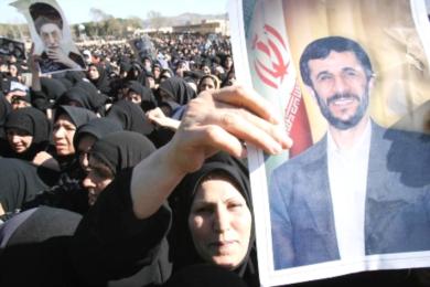 امرأة ايرانية تحمل صورة الرئيس نجاد في مظاهرة يوم امس