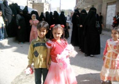 الطفلة حنان تُلتقط لها الصور التذكارية مع اقربائها من الاطفال والنساء المتجمهرات خلفها بعد عودتها