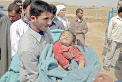 اب يحمل طفلته القتيلة بعد غارة اميركية في قرية البلاد غرب العاصمة العراقية بغداد