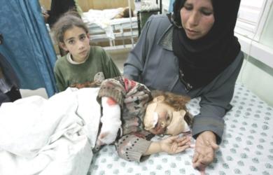 فلسطينية تعتني بطفلتها التي اصيبت في الهجوم الاسرائيلي