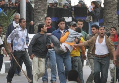مصريون يحملون احد جرحى الاشتباكات