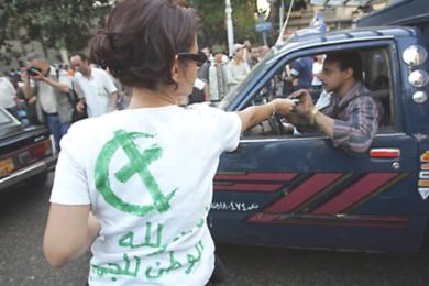 فتاة مصرية تقوم بتوزيع كتيبات للمواطنين 