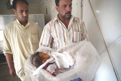 رجل عراقي يحمل جثة طفلة تبلغ من العمر 4 اشهر قتلت مع والدتها امس الاول