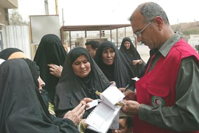 نساء عراقيات يستلمن معونات غذائية من الصليب الاحمر