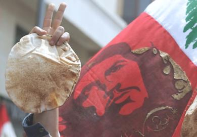 احد المتظاهرين رافعا رغيفا في عيد العمال يوم امس