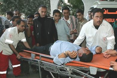 فلسطينيون يحملون رجلاً مجروحاً بعد الضربة الجوية الاسرائيلية  