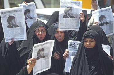 نساء شيعيات يحملن صورة رجل الدين الشيعي مقتدى الصدر في مظاهرة يوم امس