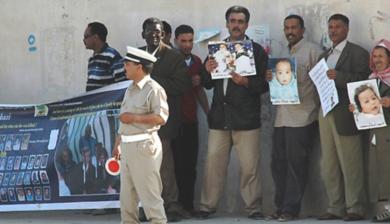 اسر الاطفال المصابين يتظاهرون امام قاعة المحكمة رافعين صورا لاطفالهم المصابين بالإيدز