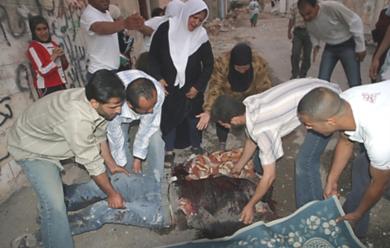 فلسطينيون يقومون بحمل جثث القتلى 