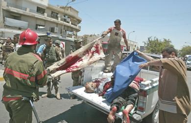 عراقيون ينقلون جثث الضحايا في احدى السيارات التابعة لشرطة العراقية