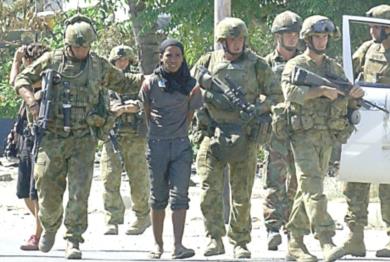 جنود استراليون يلقون القبض على احد المتمردين
