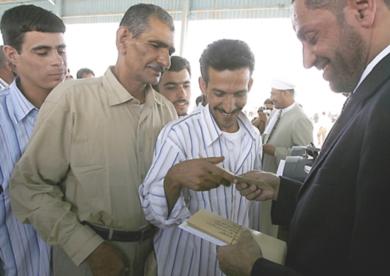 مسؤول عراقي يقوم بتقديم المساعدات المالية للمفرج عنهم