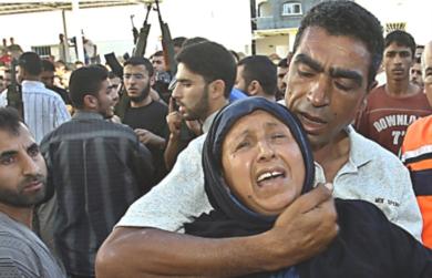 فلسطيني يحاول تهدئة امرأة فلسطينية بعد مقتل احد اقاربها في القصف الاسرائيلي