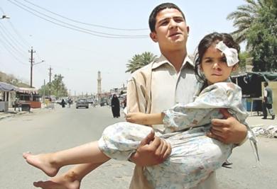 فتى عراقي يحمل اخته المصابه في احدى الهجمات
