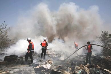 رجال الاطفاء يعملون على اخماد احد المباني المحترقة ..اثر غارة اسرائيلية