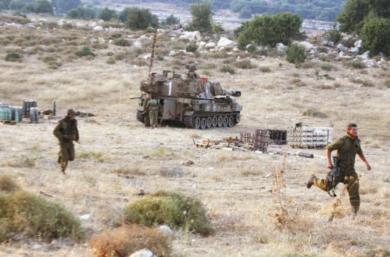 جنود اسرائيليون تابعون لفرقة مدفعية يجرون لحماية أنفسهم بعد هجوم بصواريخ كاتيوشا قرب مدينة صفد أمس