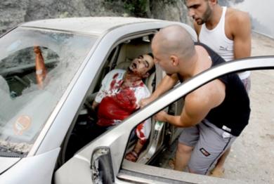مدنيون لبنانيون يحاولون اخراج جثة رجل بعد قصف اسرائيلي لضاحية كفر شيما خارج بيروت أمس