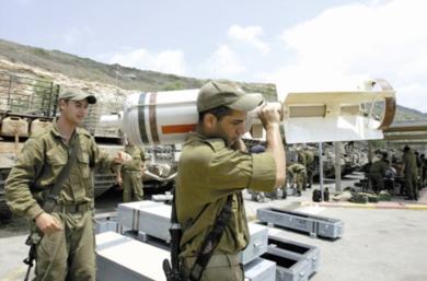جندي إسرائيلي يحمل إحدى آلات الدمار التي تطلق على لبنان.. والصورة لا تحتاج إلى تعليق