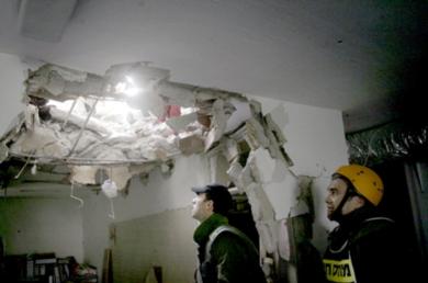 عمال الإنقاذ الإسرائيليون يتفقدون الأضرار التي أحدثها صاروخ لحزب الله في منزل بمدينة حيفا أمس