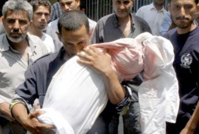المواطن اللبناني علي صفاء الدين يحمل جثة ابنته البالغة من العمر ستة أعوام بعد غارة جوية اسرائيلية على منزلهم في صور أمس
