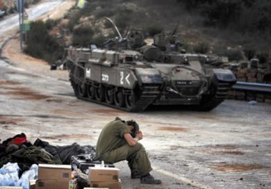 جندي إسرائيلي يأخذ قسطاً من الراحة على الحدود الإسرائيلية اللبنانية قبل التوغل في جنوب لبنان أمس