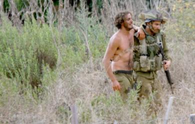 جندي إسرائيلي يساعد زميلاً له جرح في مواجهات مع مقاتلي حزب الله بجنوب لبنان أمس