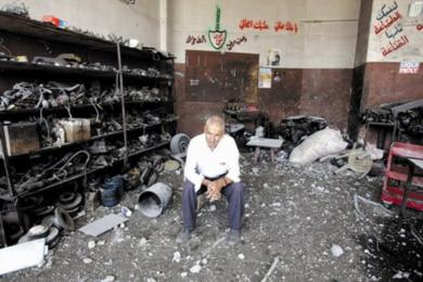 صاحب ورشة لبناني يجلس حزينا بعد أن دمرت ورشته في غارة إسرائيلية جنوب صور