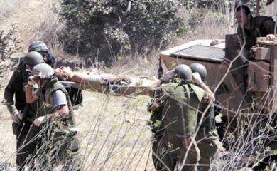 جنود إسرائيليون يحملون زميلاً لهم أصيب في معارك مع مقاتلي حزب الله بجنوب لبنان أمس