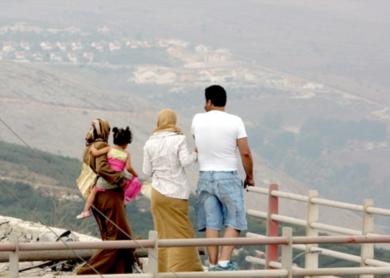 اسرة لبنانية من بلدة كفر كلا تنظر امس الى بلدة حدودية اسرائيلية