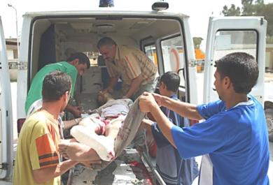 عراقيون ينقلون احد المصابين إلى سيارة الاسعاف