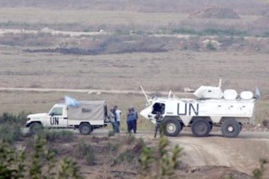قوات الأمم المتحدة تراقب الجنود الإسرائيليين والمدنيين اللبنانيين عند نقطة الحدود الإسرائيلية اللبنانية